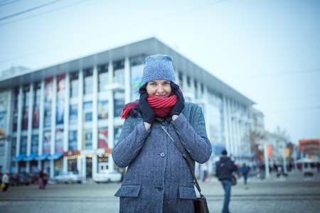 Beautiful and young girl in a hat walking in the evening cityの写真素材