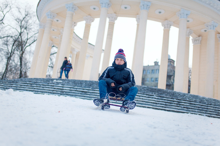 young man with sled in the snowの写真素材