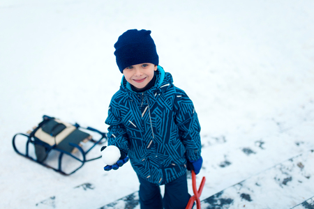 Cute five years old boy playing on winter forestの写真素材