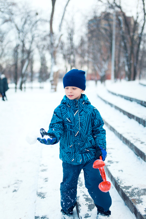 Cute five years old boy playing on winter forestの写真素材