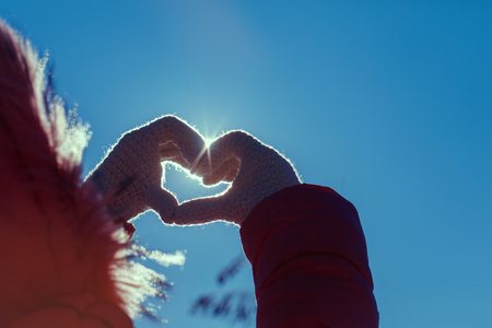 heart of the fingers against the blue skyの写真素材