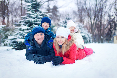 happy young family spending time outdoor in winter (focus on the father)の写真素材