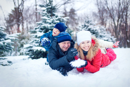 happy young family spending time outdoor in winter (focus on the father)の写真素材
