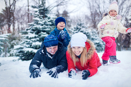 happy young family spending time outdoor in winter (focus on the father)の写真素材