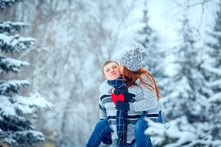 happy pair of male and female embracing and having fun wearing warm clothes outsideの写真素材