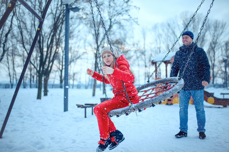 happy pair of male and female embracing and having fun wearing warm clothes outsideの写真素材