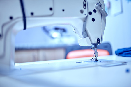 Workplace of tailor - sewing machine, rolls of of thread, fabric, scissors.の写真素材