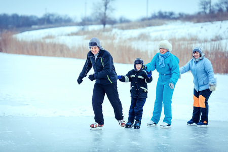 Happy family outdoor ice skating at rink.の写真素材