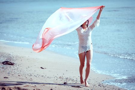 Happy woman enjoying beach relaxing joyful in summer by tropical blue water.の写真素材