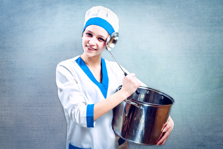 Portrait of beautiful female chef  on background.の写真素材