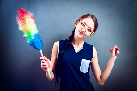 Smiling young housewife holding the dusting brushの写真素材