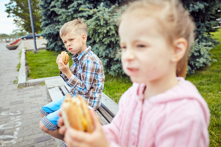Close-up of two friends eating hamburgerの写真素材