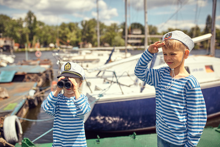 Children on the pier play sailors