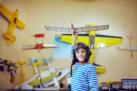 A boy in the workshop wearing a pilot's helmet
