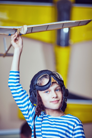 A boy in the workshop wearing a pilot's helmetの写真素材