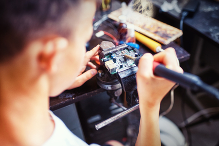 A child in the workshop is repairing the boardの写真素材
