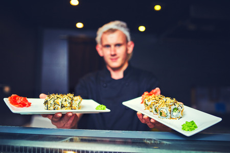 male cooks preparing sushi in the restaurant kitchen.の写真素材