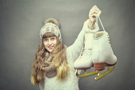 Young beautiful girl with skates on background.