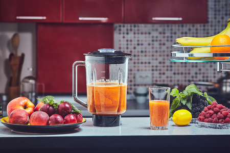 Woman making green smoothie on the kitchen. Focus on the blender.の写真素材
