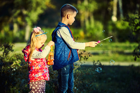 Pretty little girl blowing bubbles in the park.の写真素材