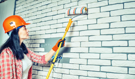 The girl in working clothes does the repairの写真素材