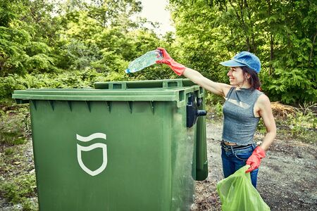 Ecology protection concept. Woman volunteer collecting garbage in parkの写真素材