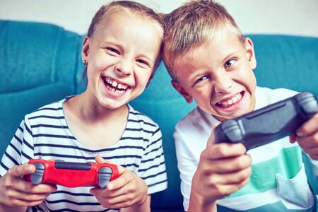 Young kids play video games on their ownの写真素材