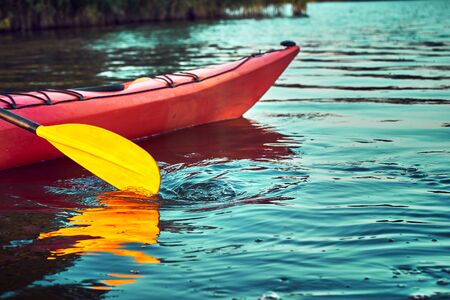 Kayaking couple ride along the river at sunset