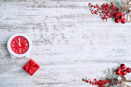 clock on background on a wooden table decorated with a garland and red Christmas balls for the New Year or XMAS. Copy spaceの写真素材