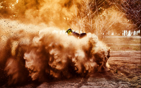 Teen riding ATV in sand dunes making a turn in the sandの写真素材