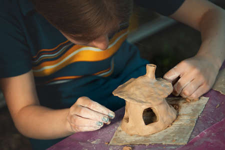 Children playing together with modeling clay and drawing by paints.