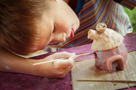 Children playing together with modeling clay and drawing by paints.の写真素材