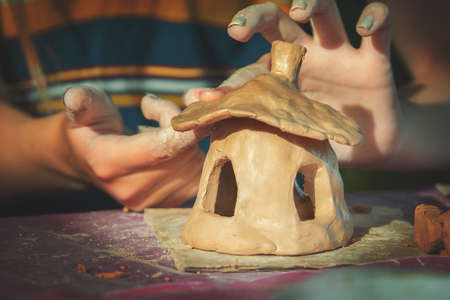 Children playing together with modeling clay and drawing by paints.
