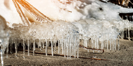 Icicle, dirty ice stalactite sharpened downward when melting dirty snowの写真素材