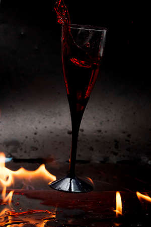 Falling cup with red liquid surrounded by fireworksの写真素材