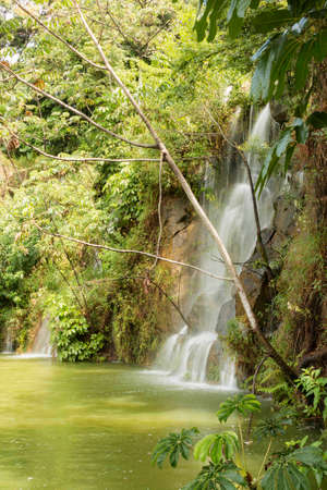Waterfall with a large volume of water that flows through several rocks.の写真素材