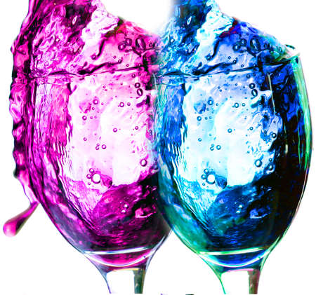 Colored liquid splash in a glass bowl. Effect in photography to show movement and give energy to the image. The photograph in question simulates a toast.の写真素材