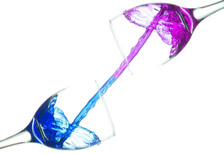 Colored liquid splash in a glass bowl. Effect in photography to show movement and give energy to the image. The photograph in question simulates a toast.の写真素材