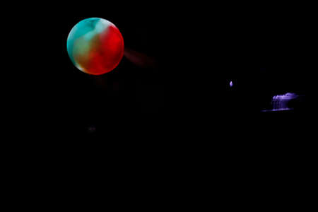Photo camera on a wooden bench in a photo studio in the background with a trail of colored light.の写真素材