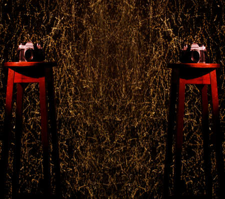 Photo camera on a wooden bench in a photo studio in the background with a trail of colored light.の写真素材