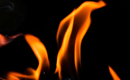 Water mixed with lighter fluid inside a golden pot throwing ice stone to cause thermal shock and cause a splash of liquid with fire on the black background.の写真素材