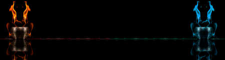 Water mixed with lighter fluid inside a golden pot throwing ice stone to cause thermal shock and cause a splash of liquid with fire on the black background.の写真素材