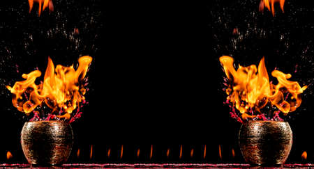 Water mixed with lighter fluid inside a golden pot throwing ice stone to cause thermal shock and cause a splash of liquid with fire on the black background.の写真素材