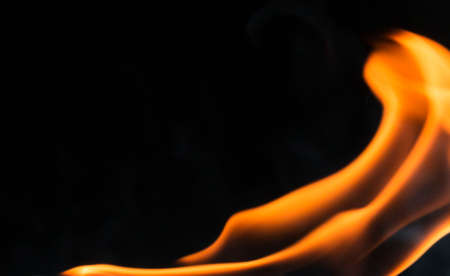 Water mixed with lighter fluid inside a golden pot throwing ice stone to cause thermal shock and cause a splash of liquid with fire on the black background.の写真素材