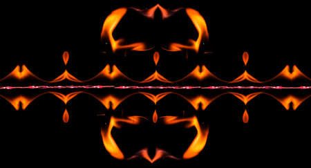 Water mixed with lighter fluid inside a golden pot throwing ice stone to cause thermal shock and cause a splash of liquid with fire on the black background.の写真素材