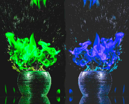 Water mixed with lighter fluid inside a golden pot throwing ice stone to cause thermal shock and cause a splash of liquid with fire on the black background.の写真素材
