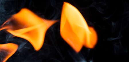 Water mixed with lighter fluid inside a golden pot throwing ice stone to cause thermal shock and cause a splash of liquid with fire on the black background.の写真素材