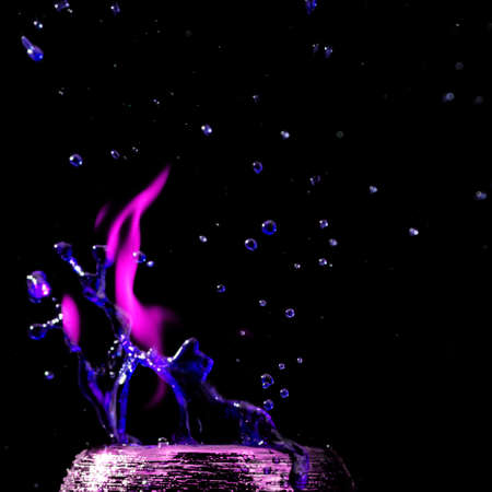 Water mixed with lighter fluid inside a golden pot throwing ice stone to cause thermal shock and cause a splash of liquid with fire on the black background.の写真素材