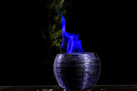 Water mixed with lighter fluid inside a golden pot throwing ice stone to cause thermal shock and...