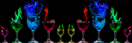 Colored liquid mixed with lighter fluid in a flaming cup where ice cubes are being placed to cause a thermal shock and generate an explosion.の写真素材